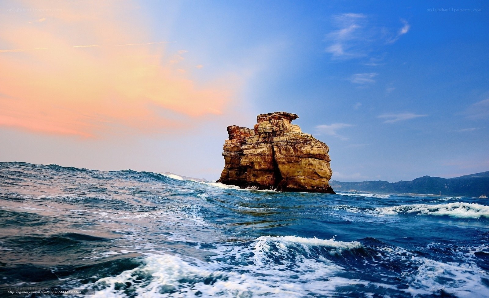 Rock formation in ocean at sunset