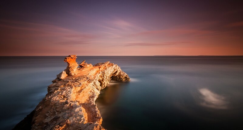 Rock Formation in Ocean — Purple, Serene, Sunset
