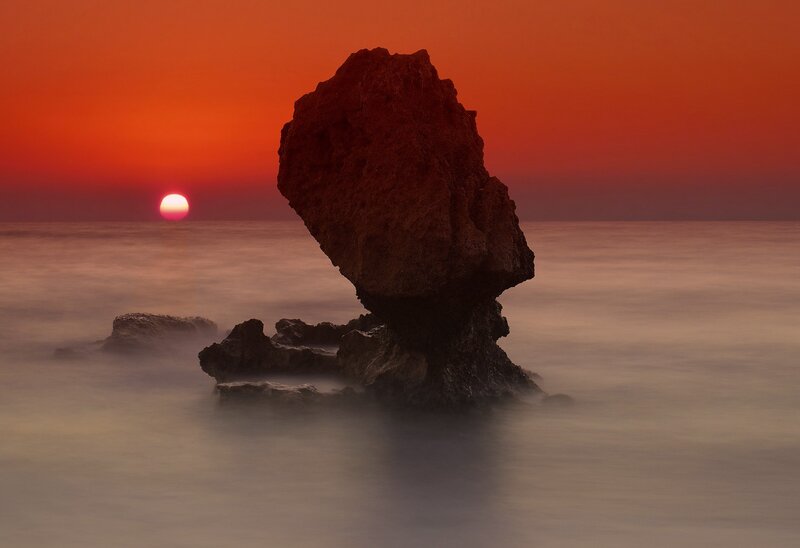 Rock Formation in Ocean — Red, Serene