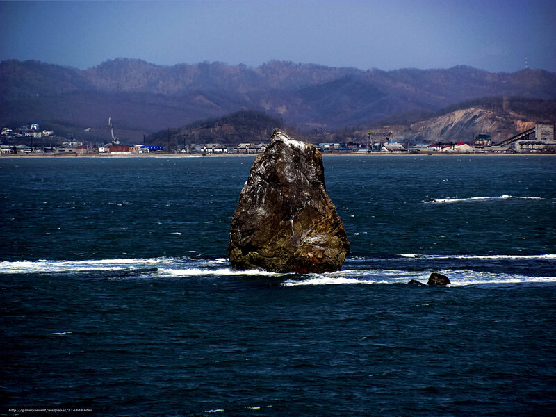 Rock formation in sea near town