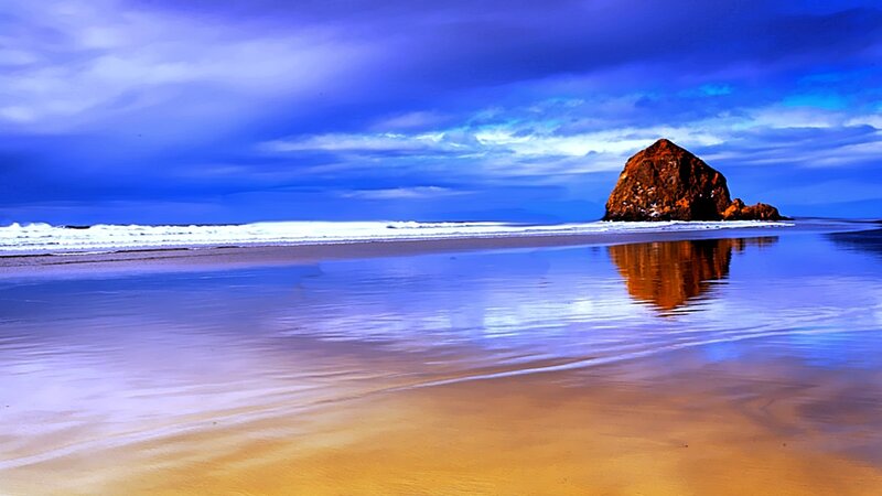 Rock formation on beach at sunset