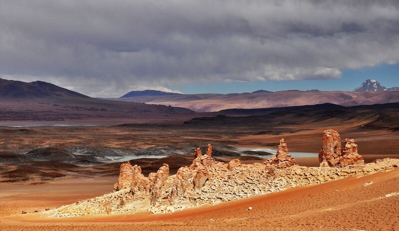 Rock Formations in Desert — Brown, Dramatic, Afternoon, Photograph, Mountains, Clouds, Lake