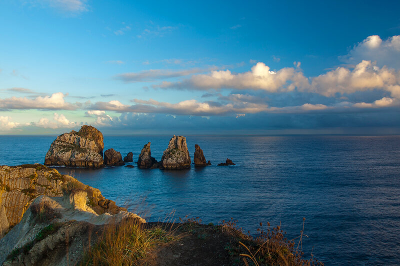 Rock Formations in Ocean — Blue, Serene, Sunset, Photograph, Sky, Clouds, Cliffs