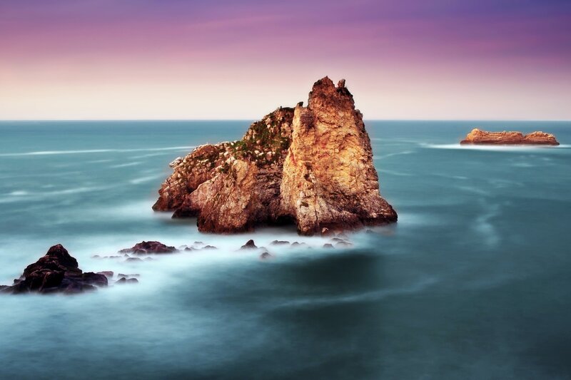 Rock formations in the sea at sunset