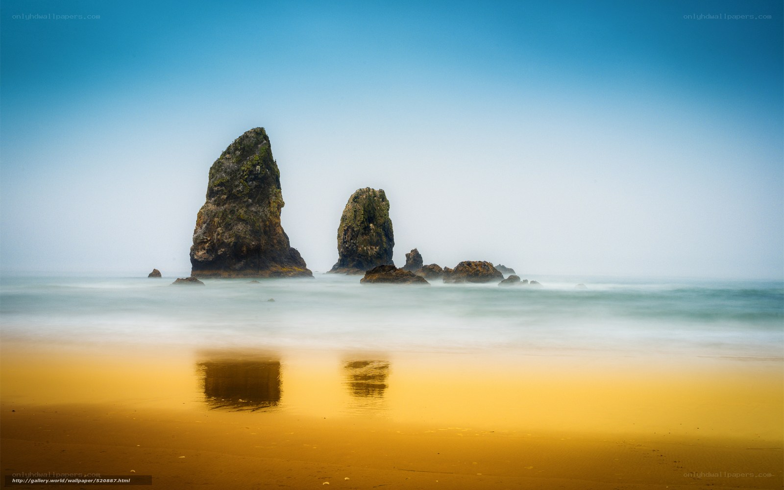 Rock formations on beach at sunset