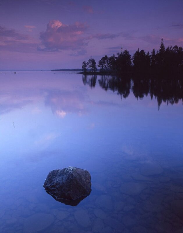 Rock in a calm lake at dusk