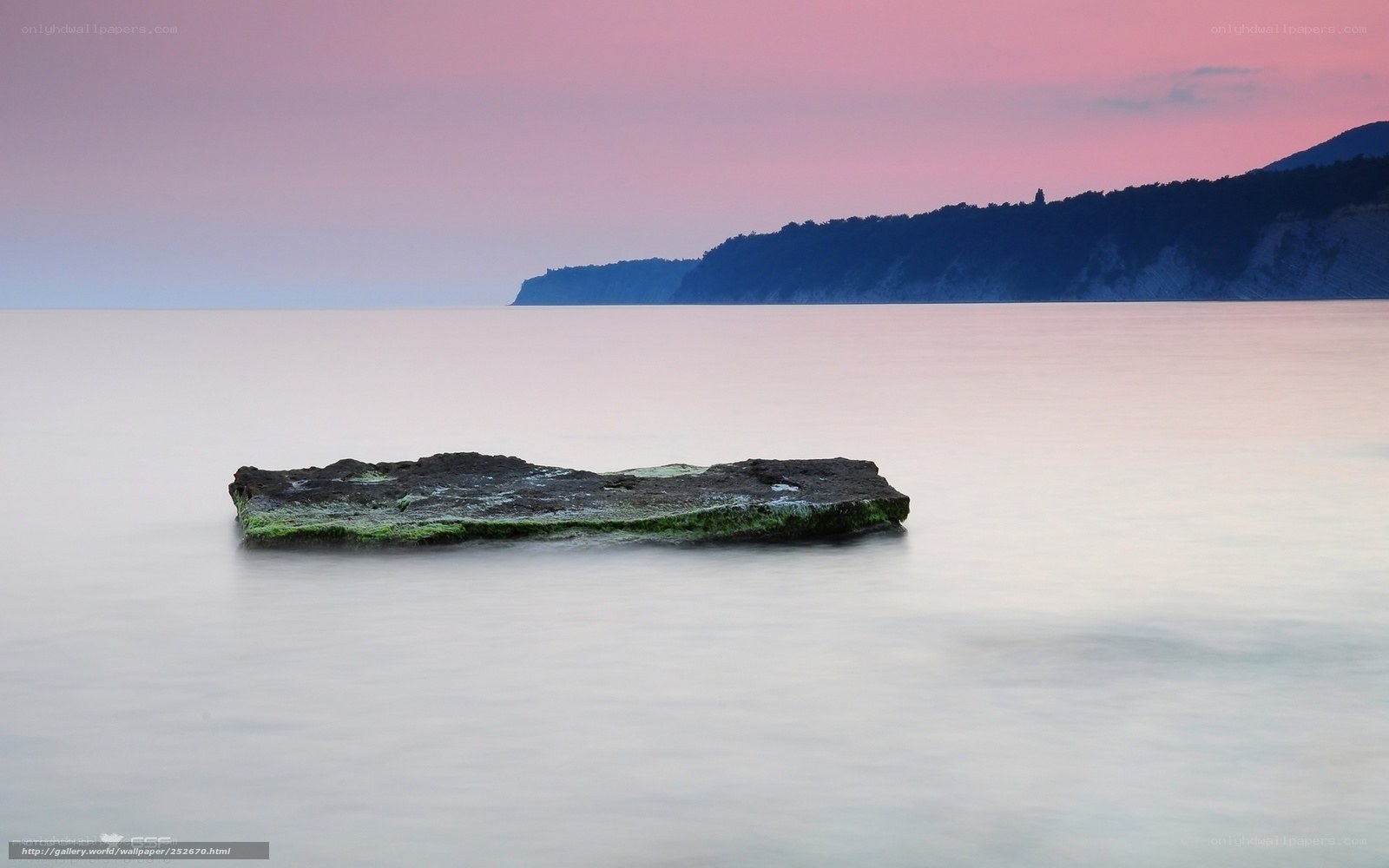Rock in calm sea at sunset