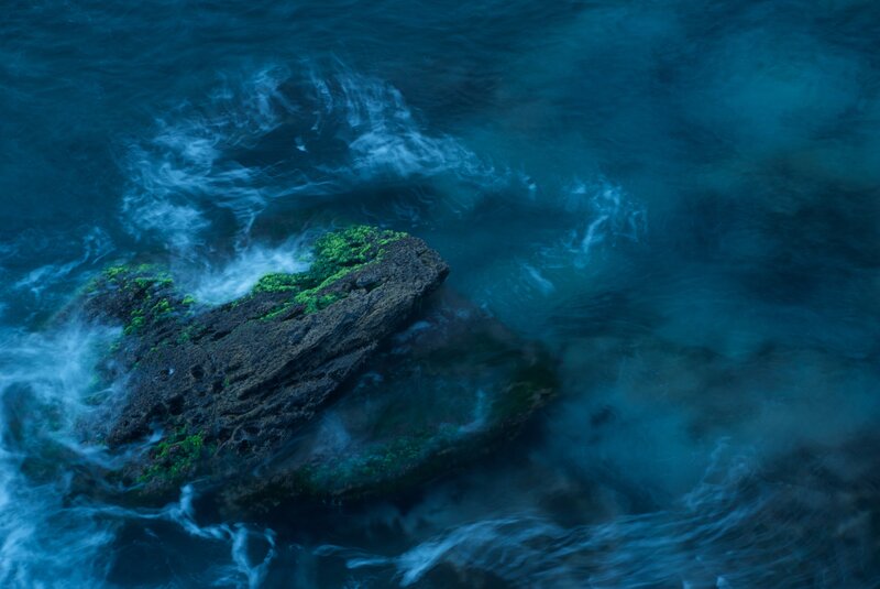 rock in turbulent blue water