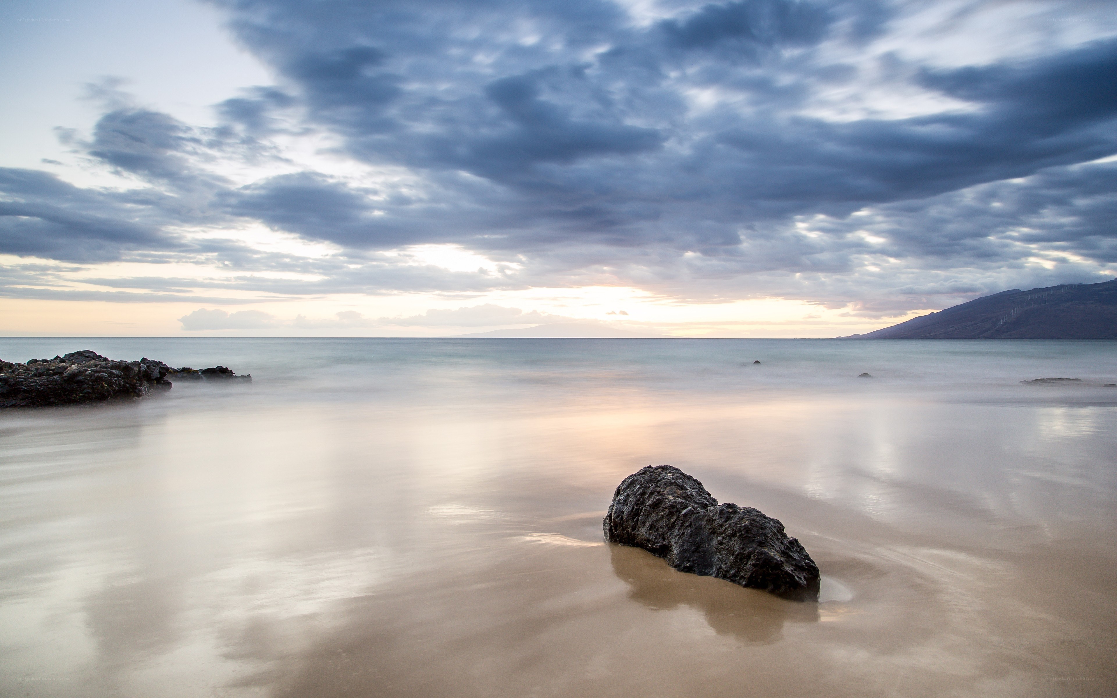 Rock on the beach at sunset