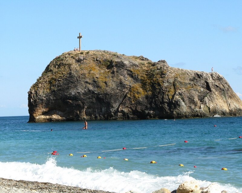 Rock with cross on beach