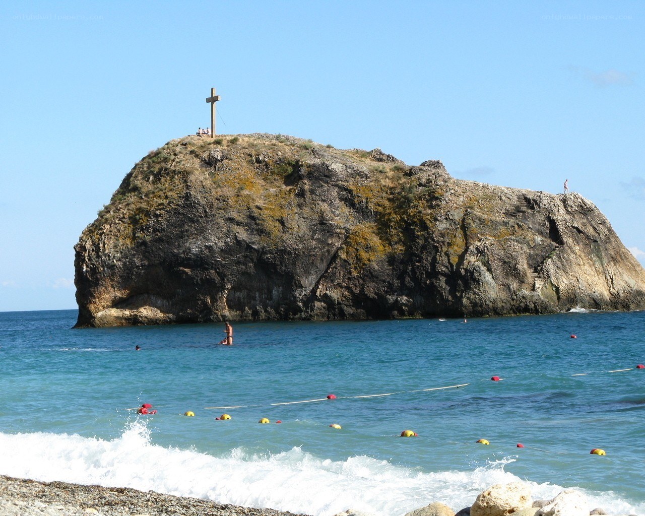 Rock with cross on beach
