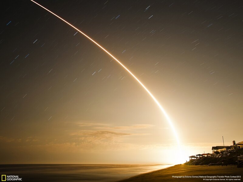 Rocket launch over beach at night