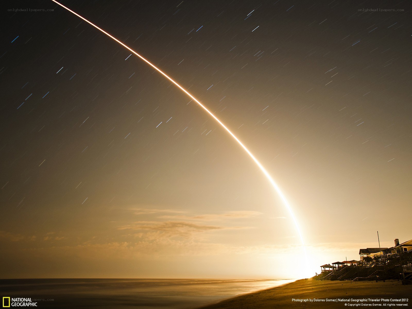 Rocket launch over beach at night