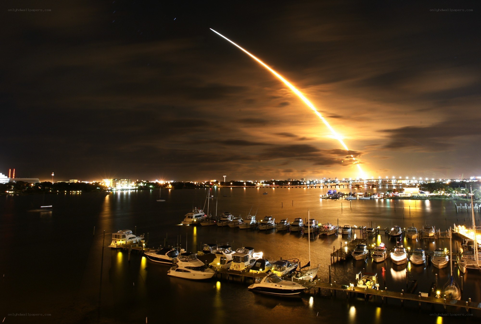 Rocket launch over marina at night