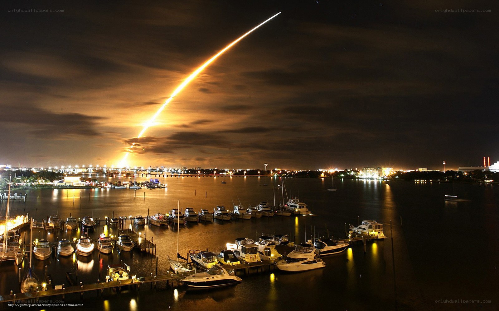 Rocket launch over marina at night