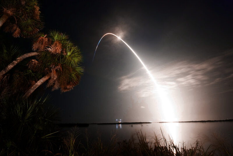 Rocket launch over water at night