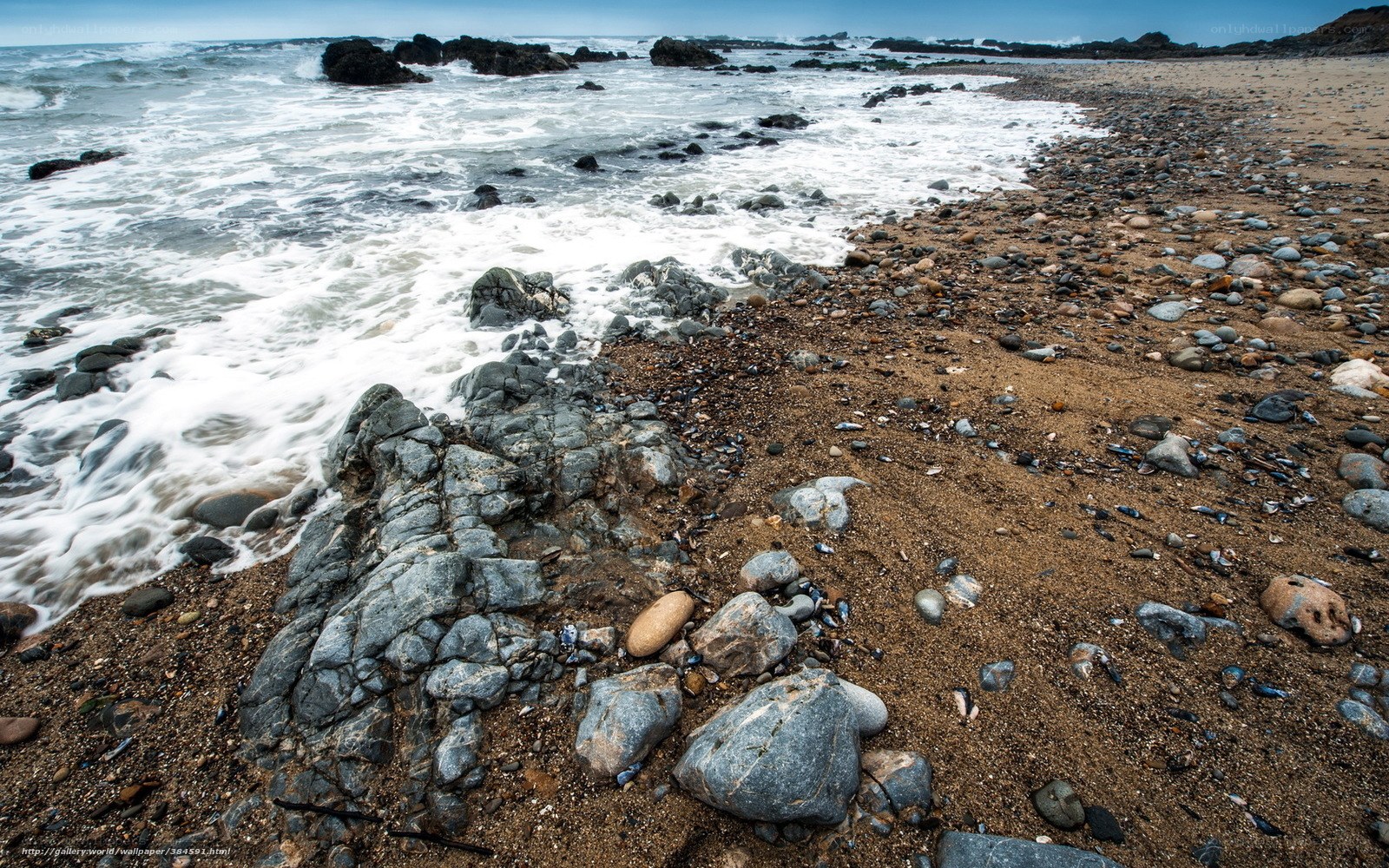 Rocks and waves on a sandy shore