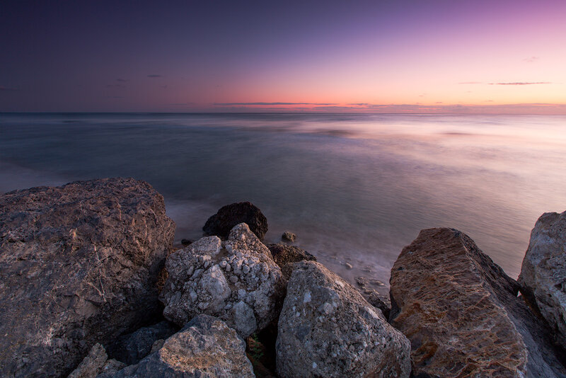Rocks at Ocean Shoreline — Purple, Serene, Sunset