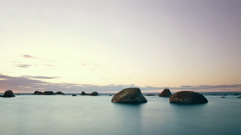 rocks in calm sea at sunset