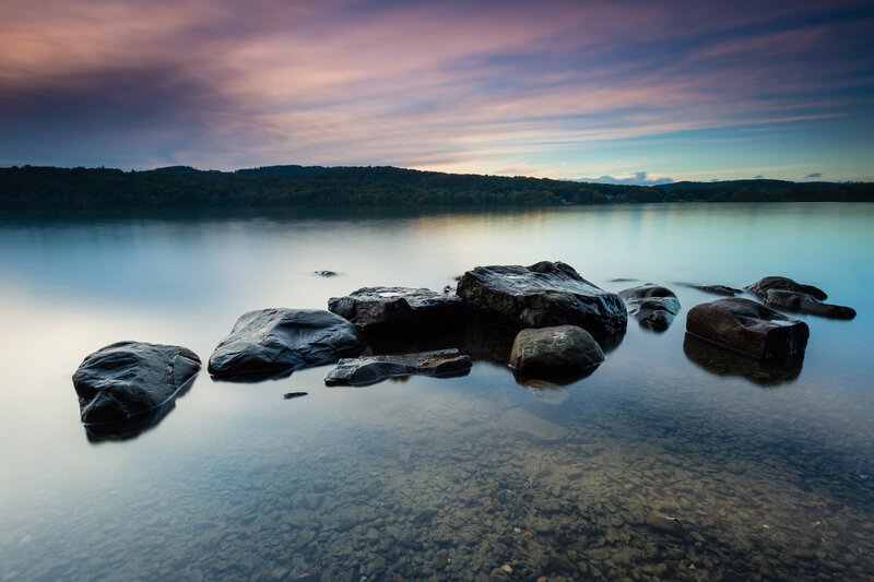 Rocks in Calm Water — Blue, Serene, Sunset, Photograph, Lake