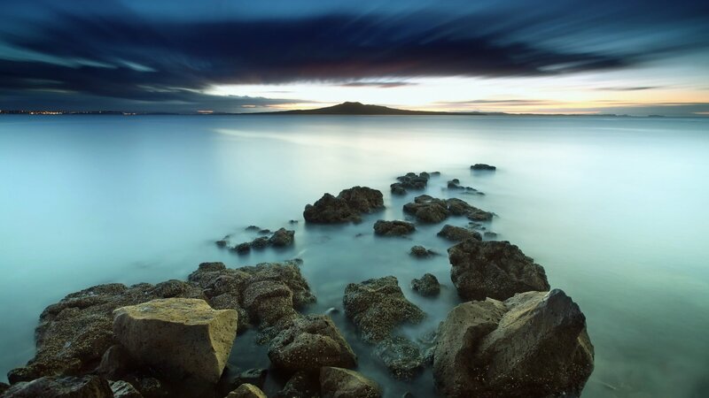 Rocks in Calm Water — Blue, Serene, Sunset, Photograph, Sea, Mountain