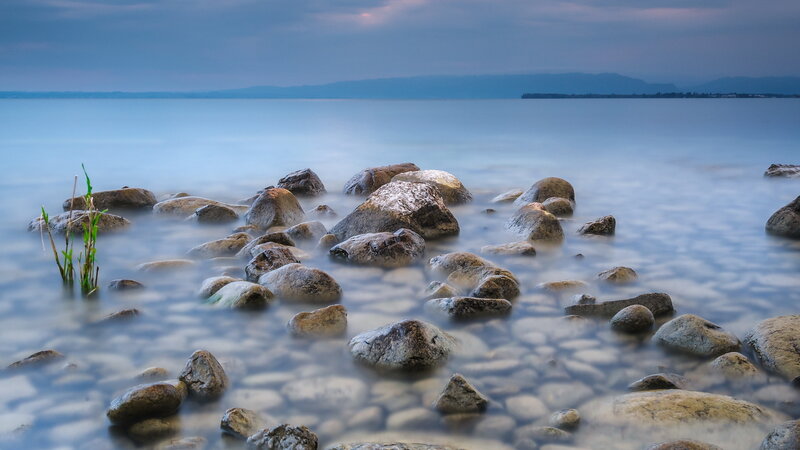 Rocks in Calm Water — Blue, Serene, Sunset, Photograph, Sky, Plants