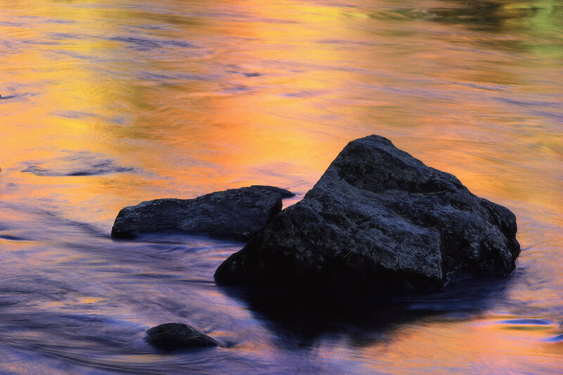 rocks in flowing water at sunset