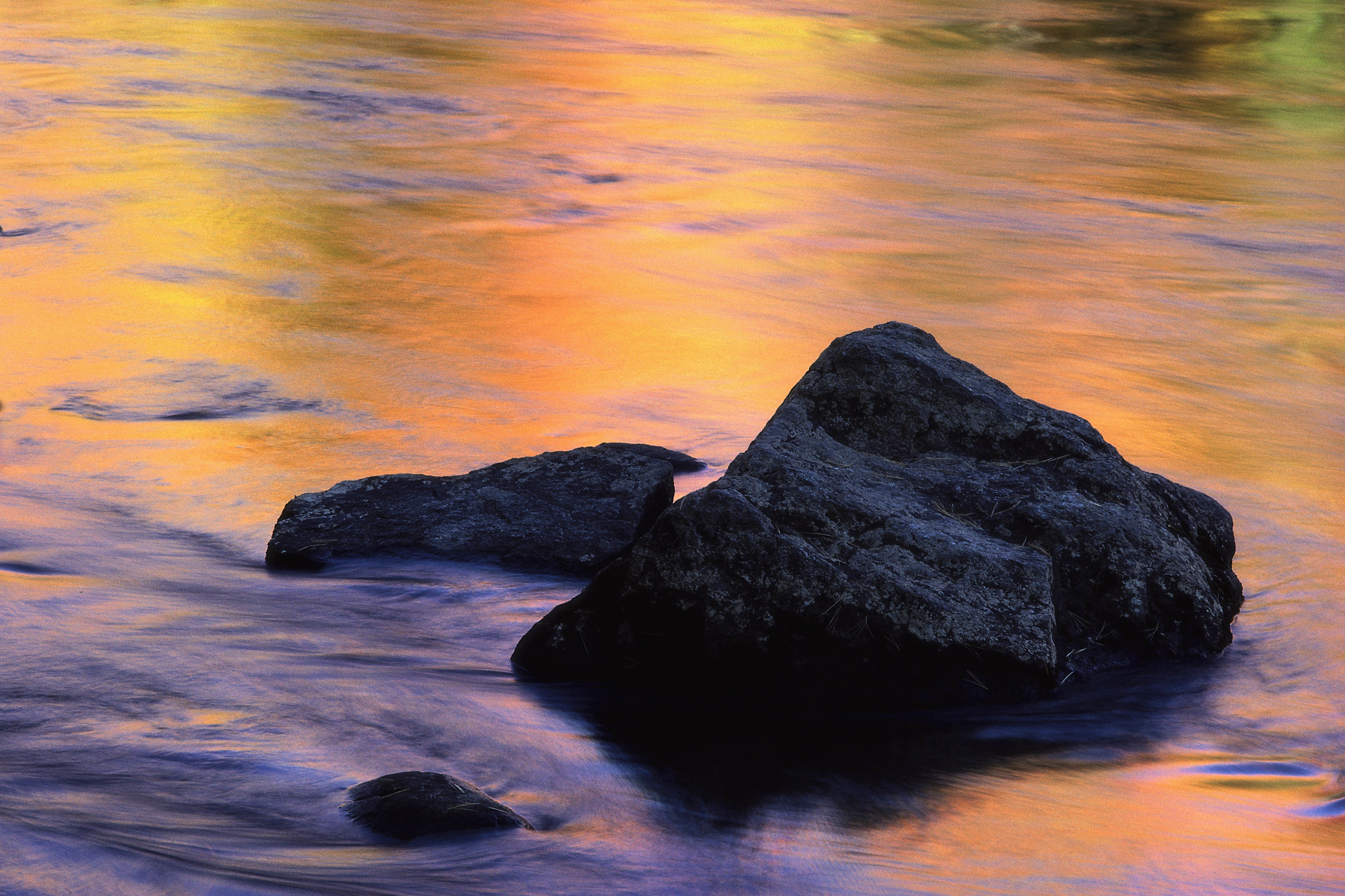 rocks in flowing water at sunset