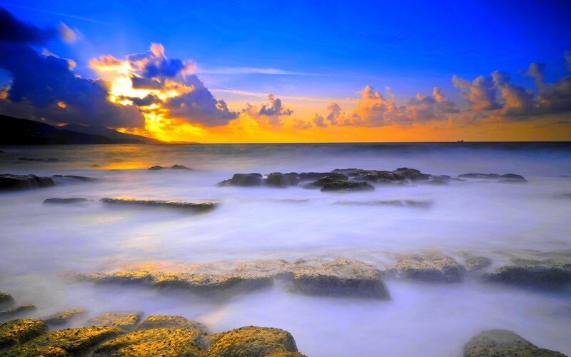Rocks in Ocean at Sunset — Blue