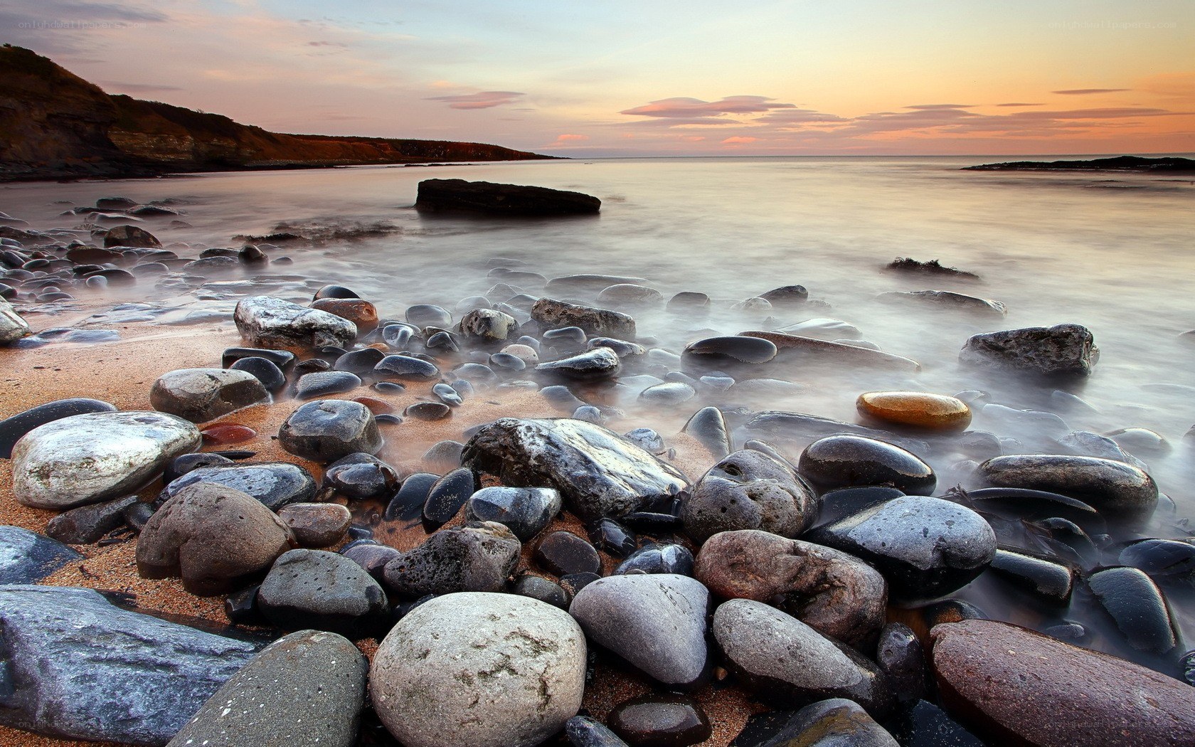 rocks on a beach at sunset