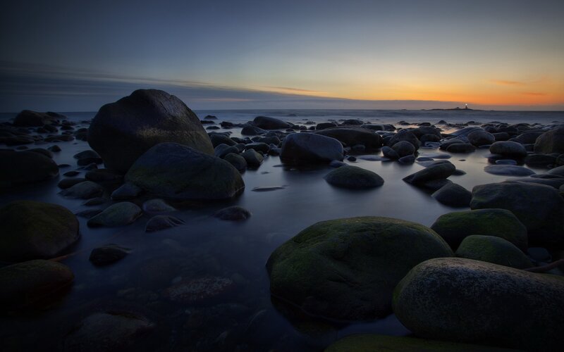 Rocks on Beach at Dusk — Blue, Serene, Sunset, Photograph, Ocean, Sky, Lighthouse