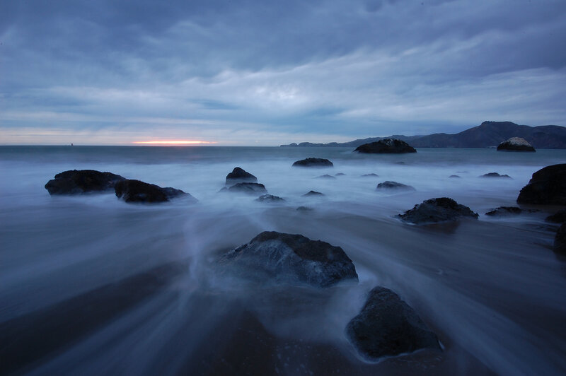 Rocks on Beach at Dusk — Blue, Serene, Sunset, Photograph, Ocean, Sky, Mountains