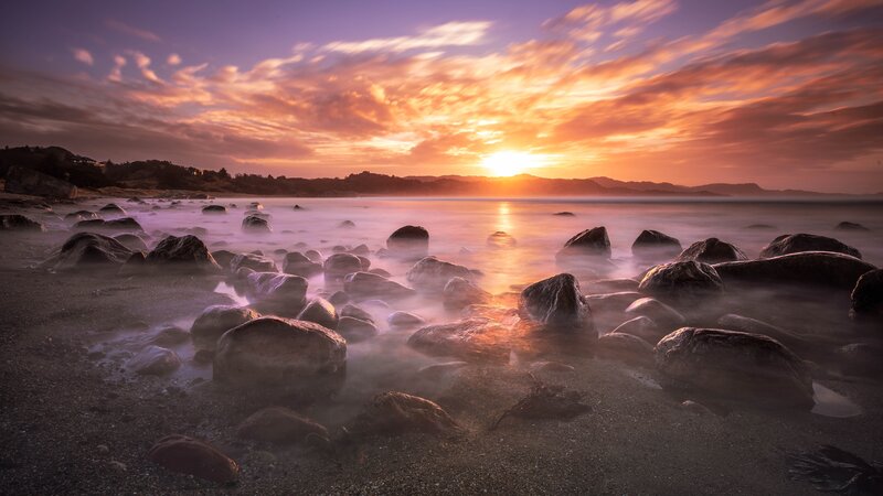 Rocks on Beach at Sunset — Orange, Serene, Photograph, Sky, Ocean, Mountains