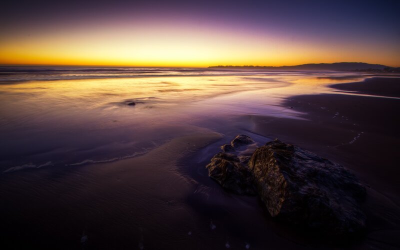 Rocks on Beach at Sunset — Purple, Serene, Photograph, Ocean, Sky, Mountains