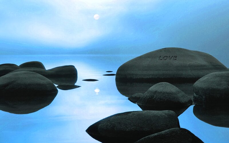 Rocks with 'LOVE' on a calm lake