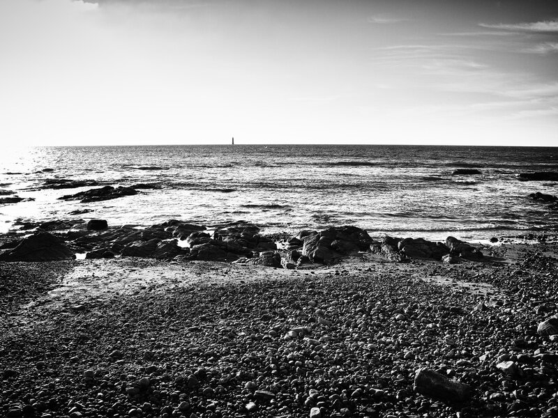 Rocky beach with distant lighthouse