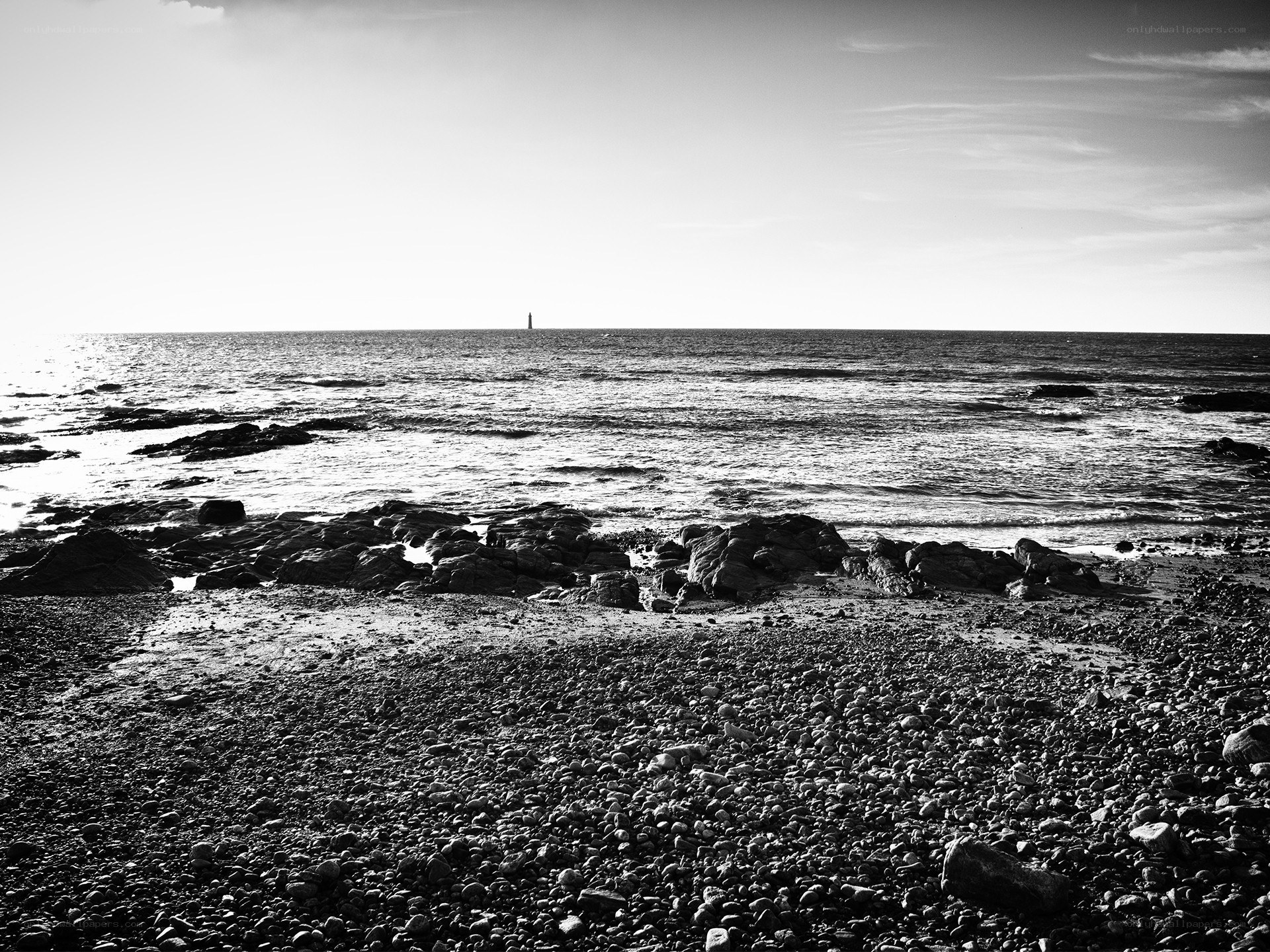Rocky beach with distant lighthouse