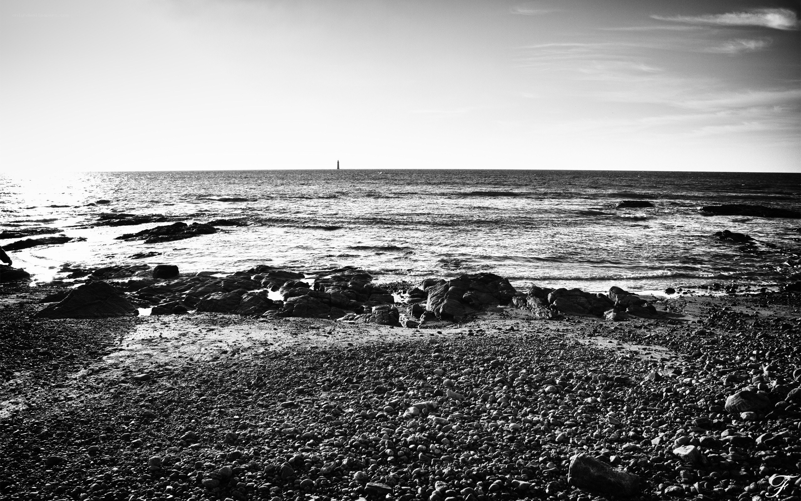 Rocky beach with distant lighthouse