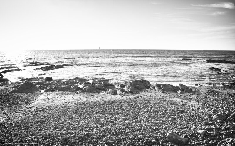 Rocky beach with distant lighthouse