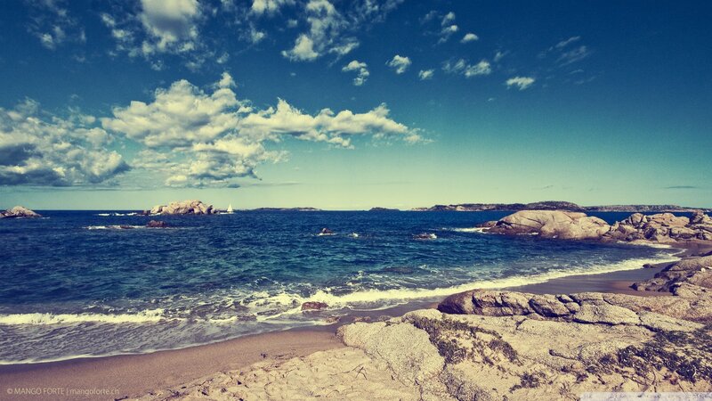 Rocky beach with sailboat