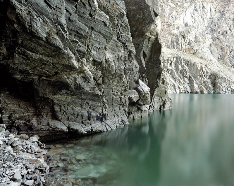 rocky cliff by calm water