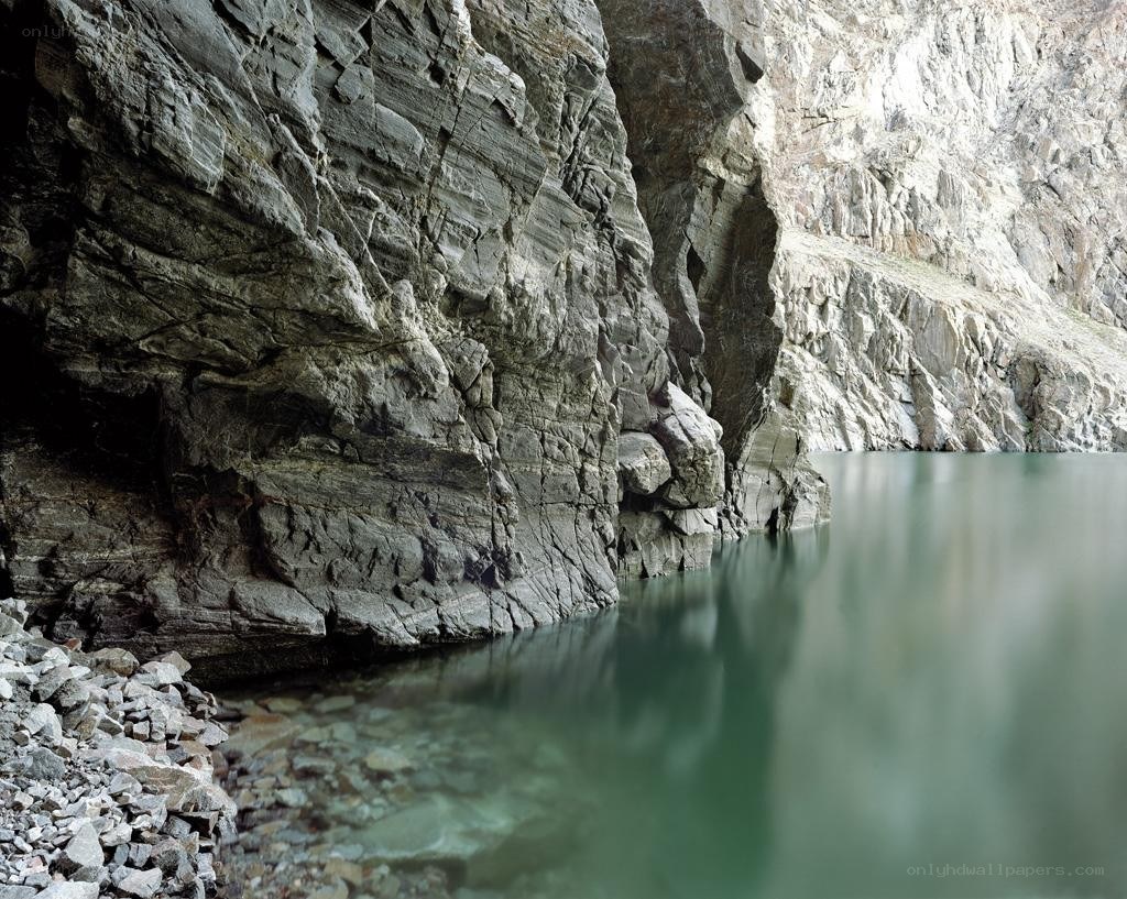 rocky cliff by calm water