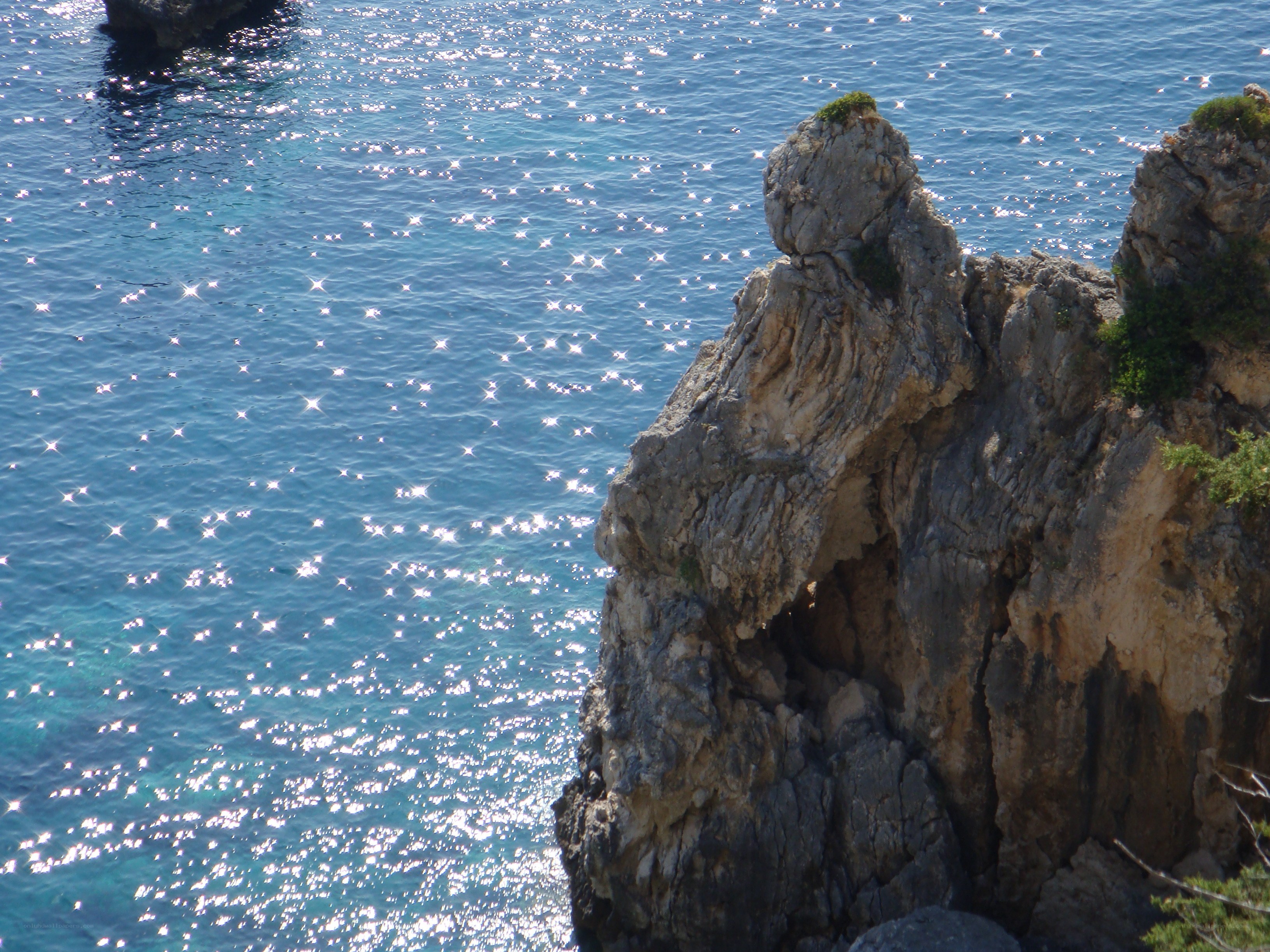 rocky cliff by sparkling sea