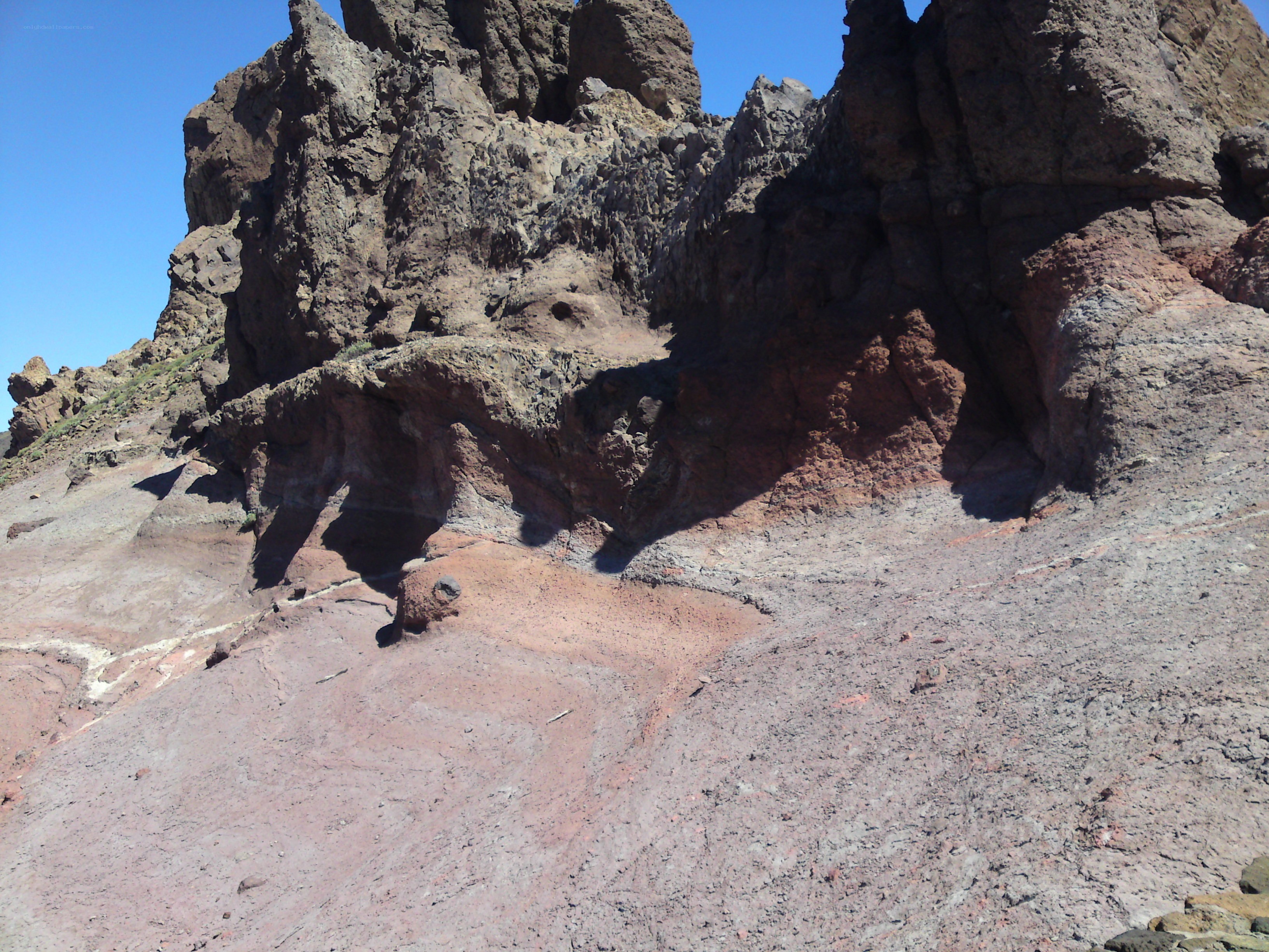 rocky cliff face under blue sky
