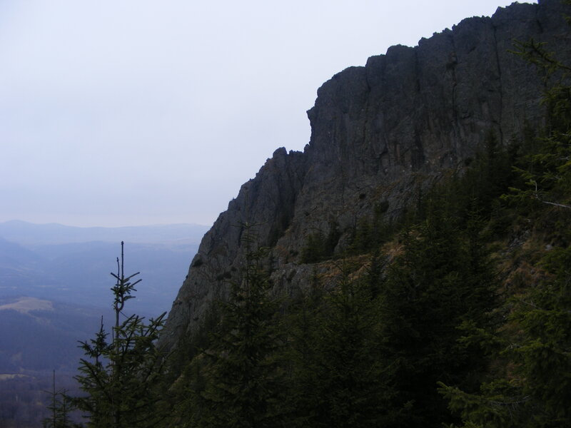 rocky cliff in forested mountains