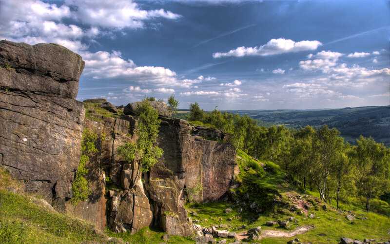 Rocky cliff overlooking green hills