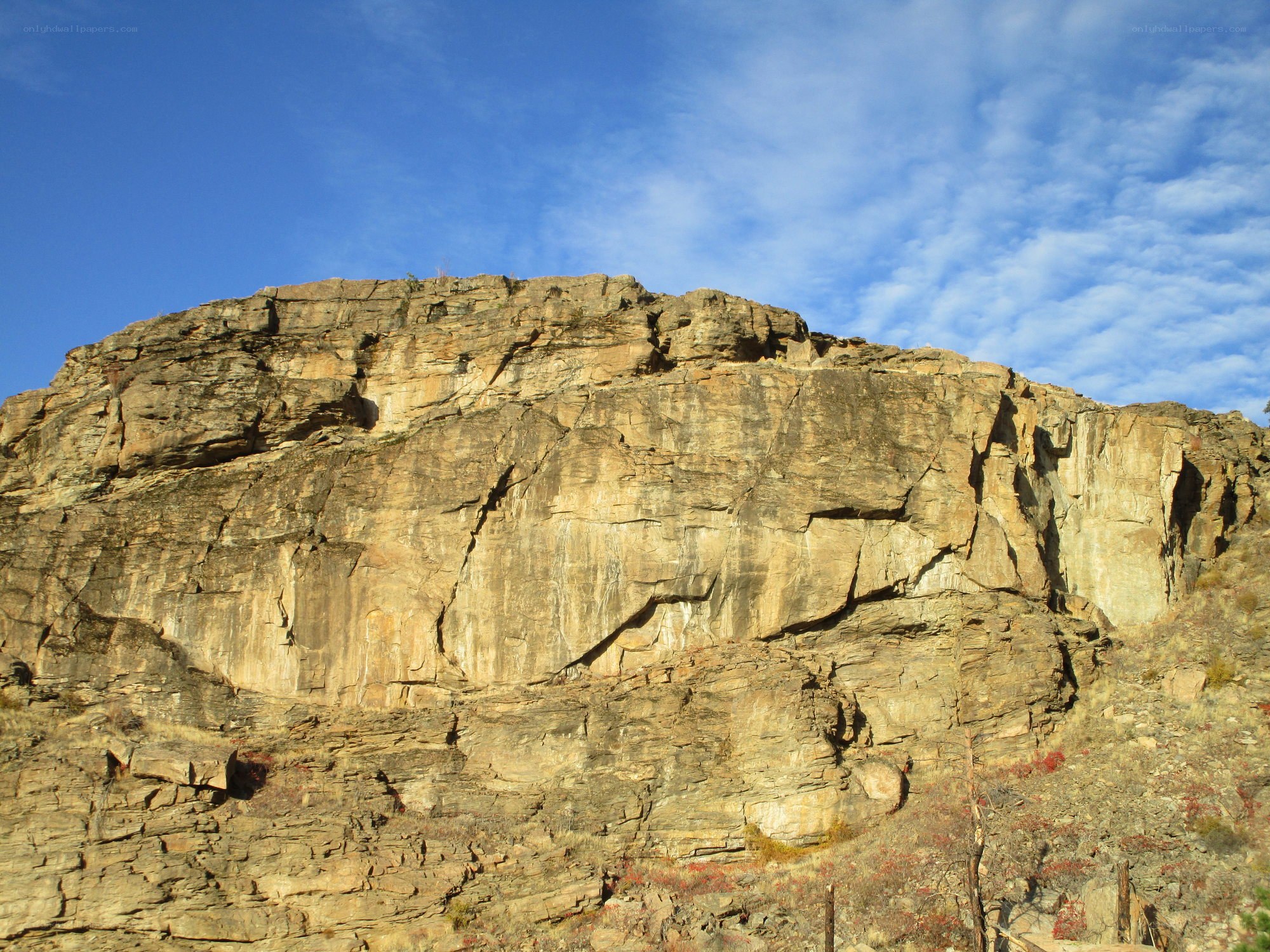 rocky cliff under blue sky