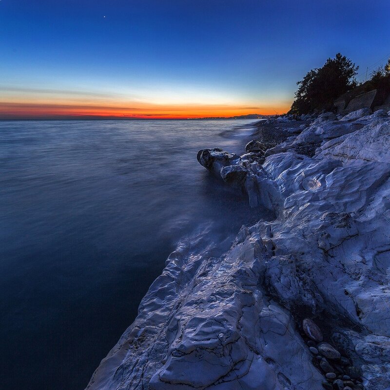 Rocky Coastline at Dusk — Blue, Serene, Sunset, Photograph, Ocean, Sky, Trees