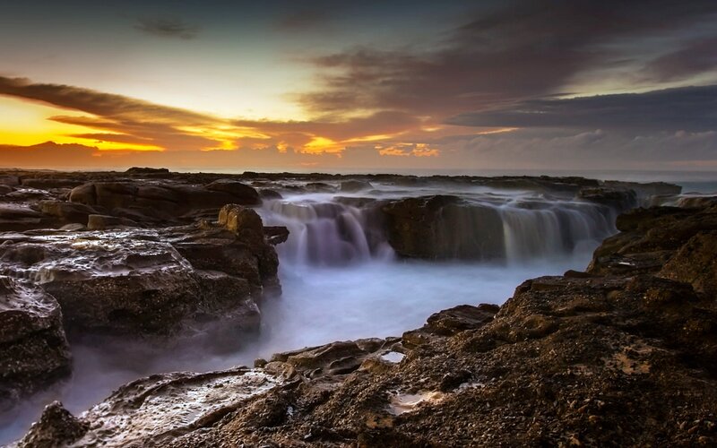 Rocky Coastline Waterfall — Orange, Dramatic
