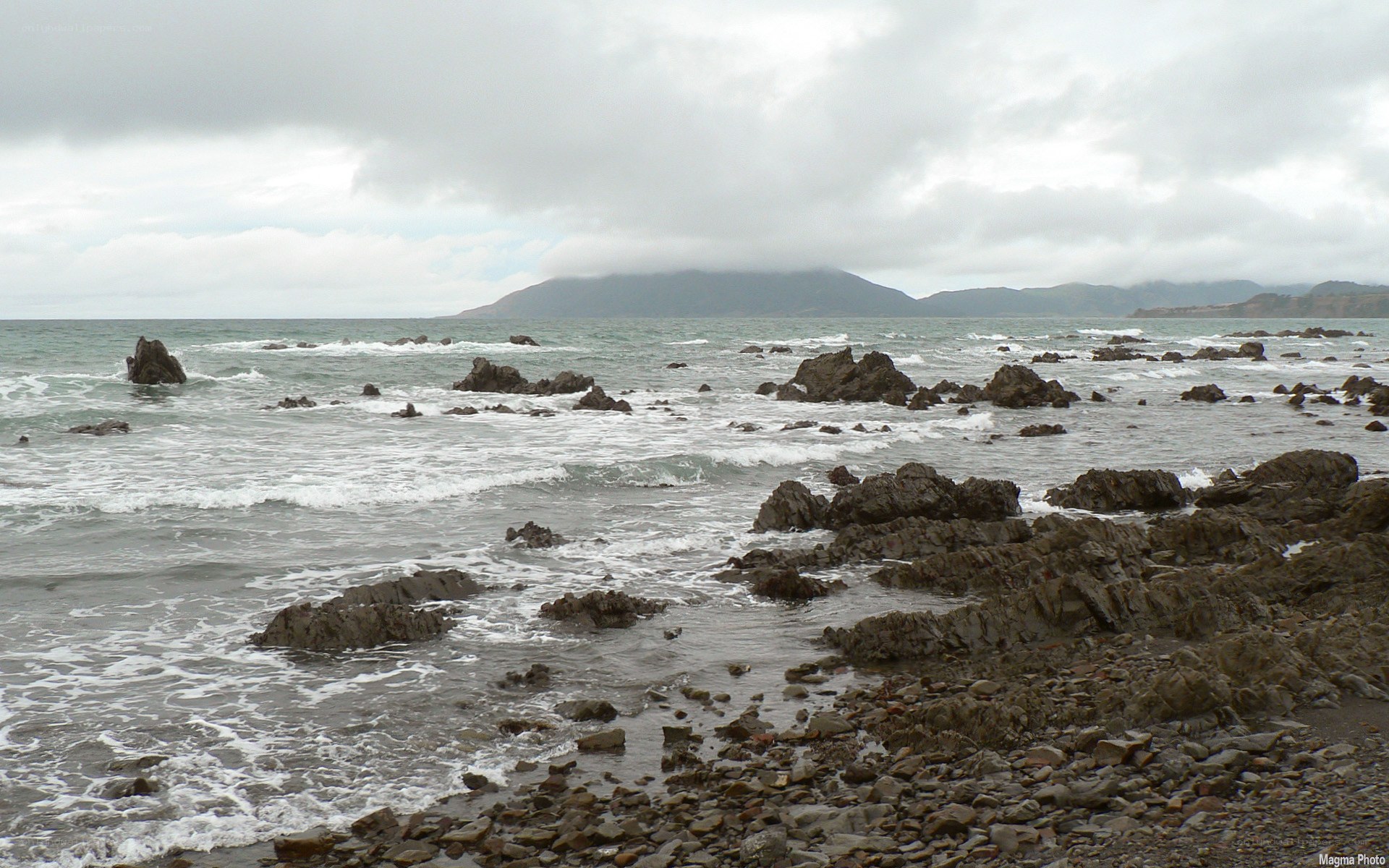 rocky coastline with distant mountains